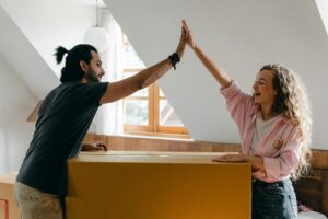 A man and a woman high fiving while packing.
